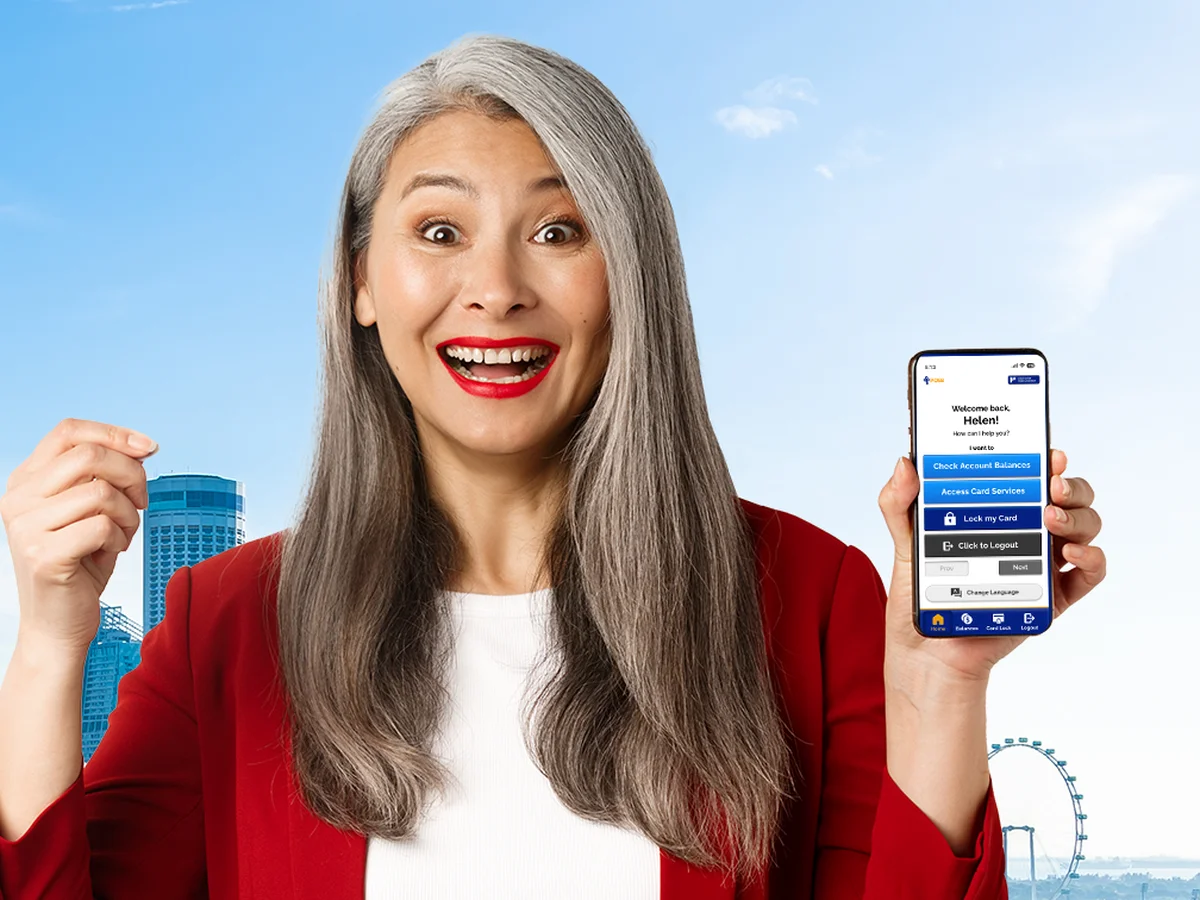 A smiling senior woman holding up her phone showing POSB Senior Mode